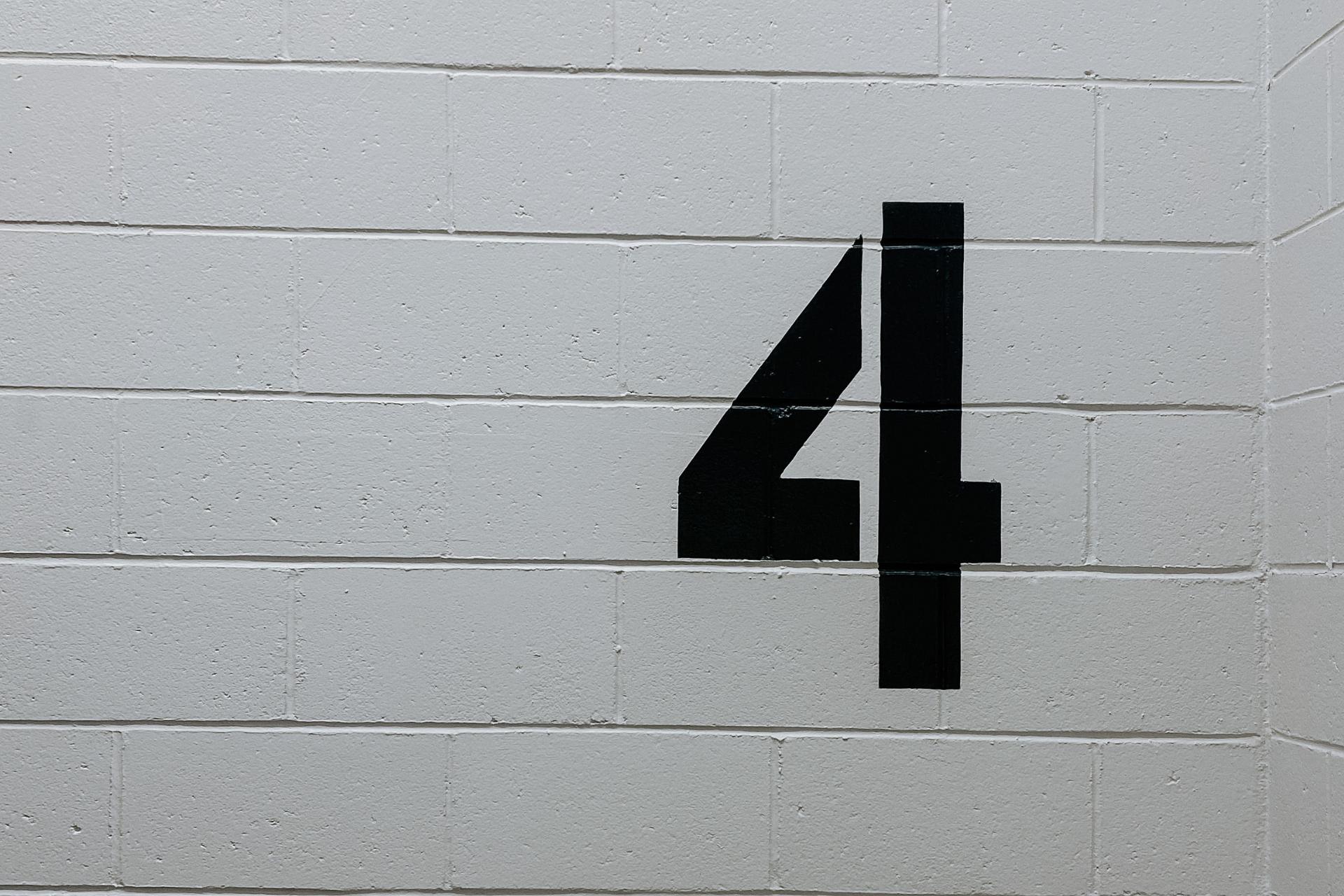 Number 4 painted on a wall. This image prepresents the 4 vital elements of restaurant administration.