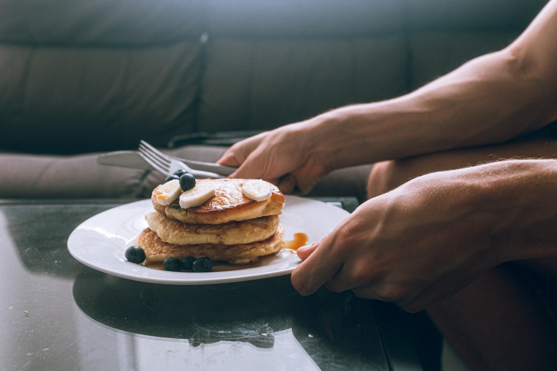 Een man met een havermoutpannekoek met banaan