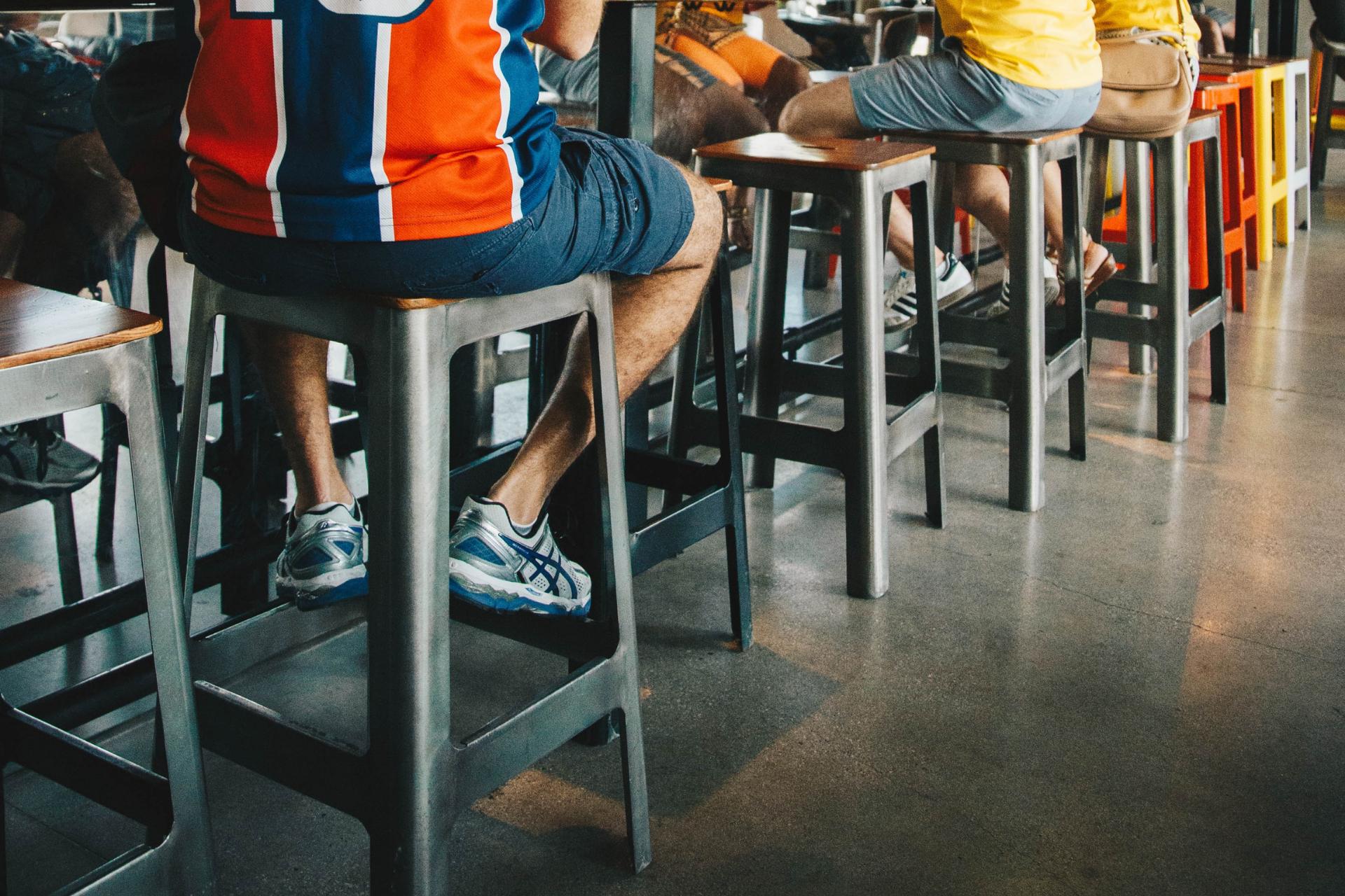 varias personas sentadas en bancos altos para bar