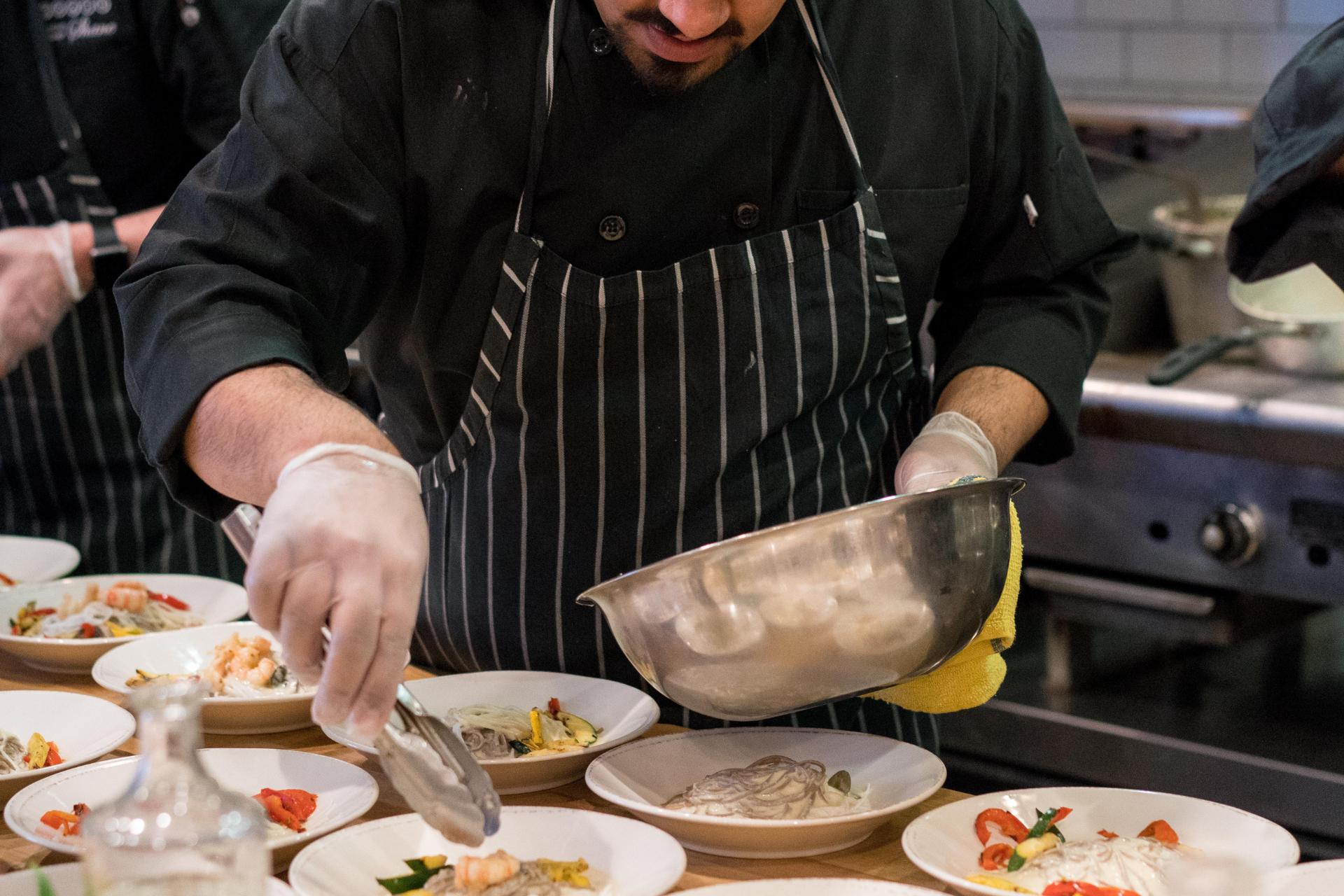 Chef emplatando comida en medio del servicio en un restaurante