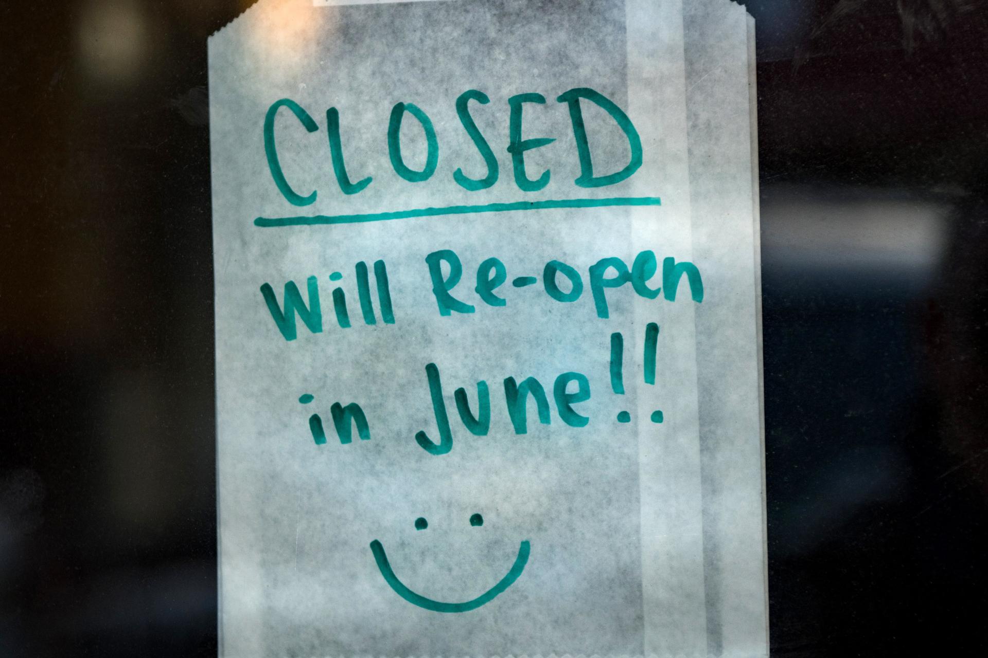 Volante que dice 'cerrado, se volverá a abrir en junio' en la ventana de un restaurante