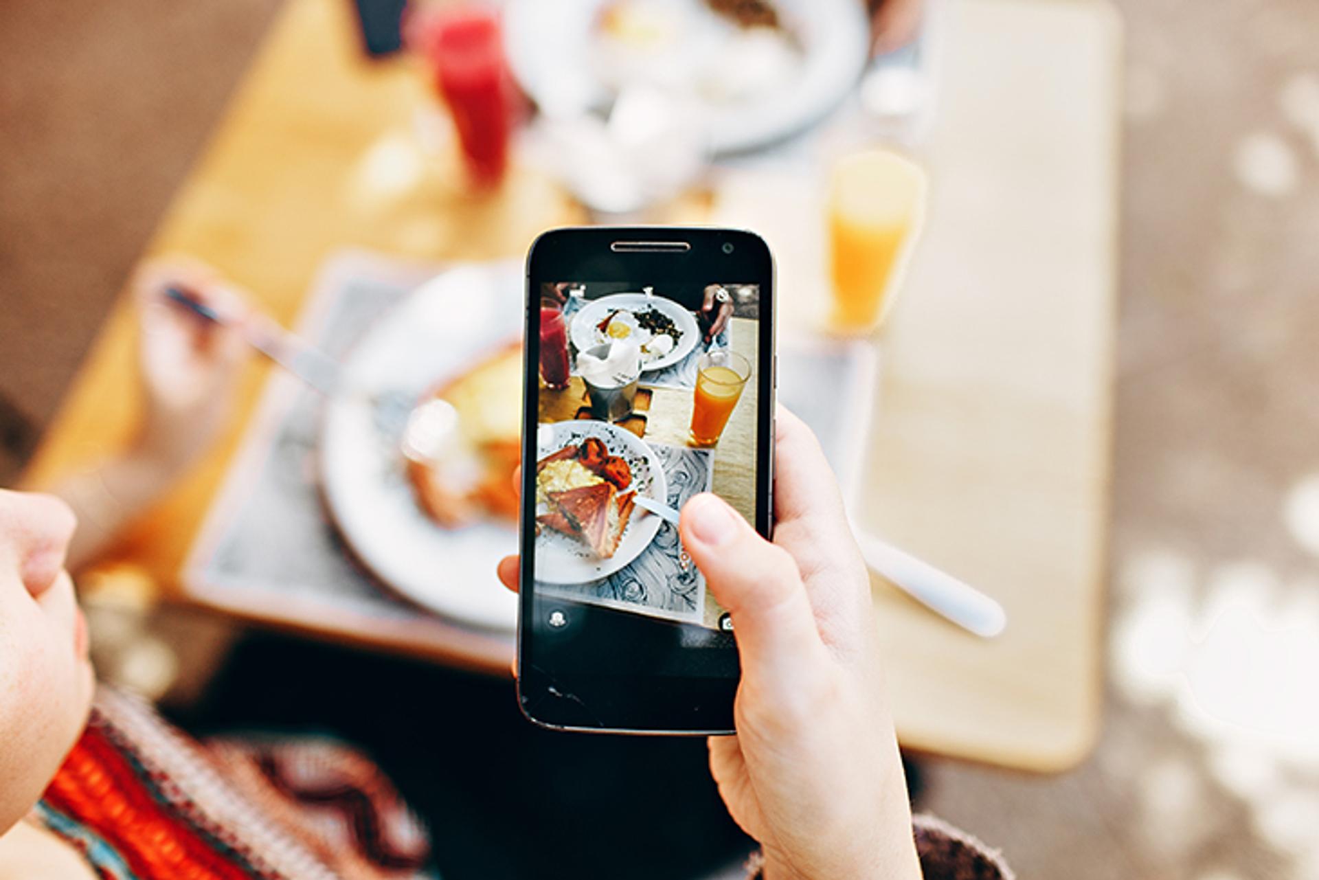 cliente passando a palavra nas redes sociais sobre os melhores pratos do seu restaurante