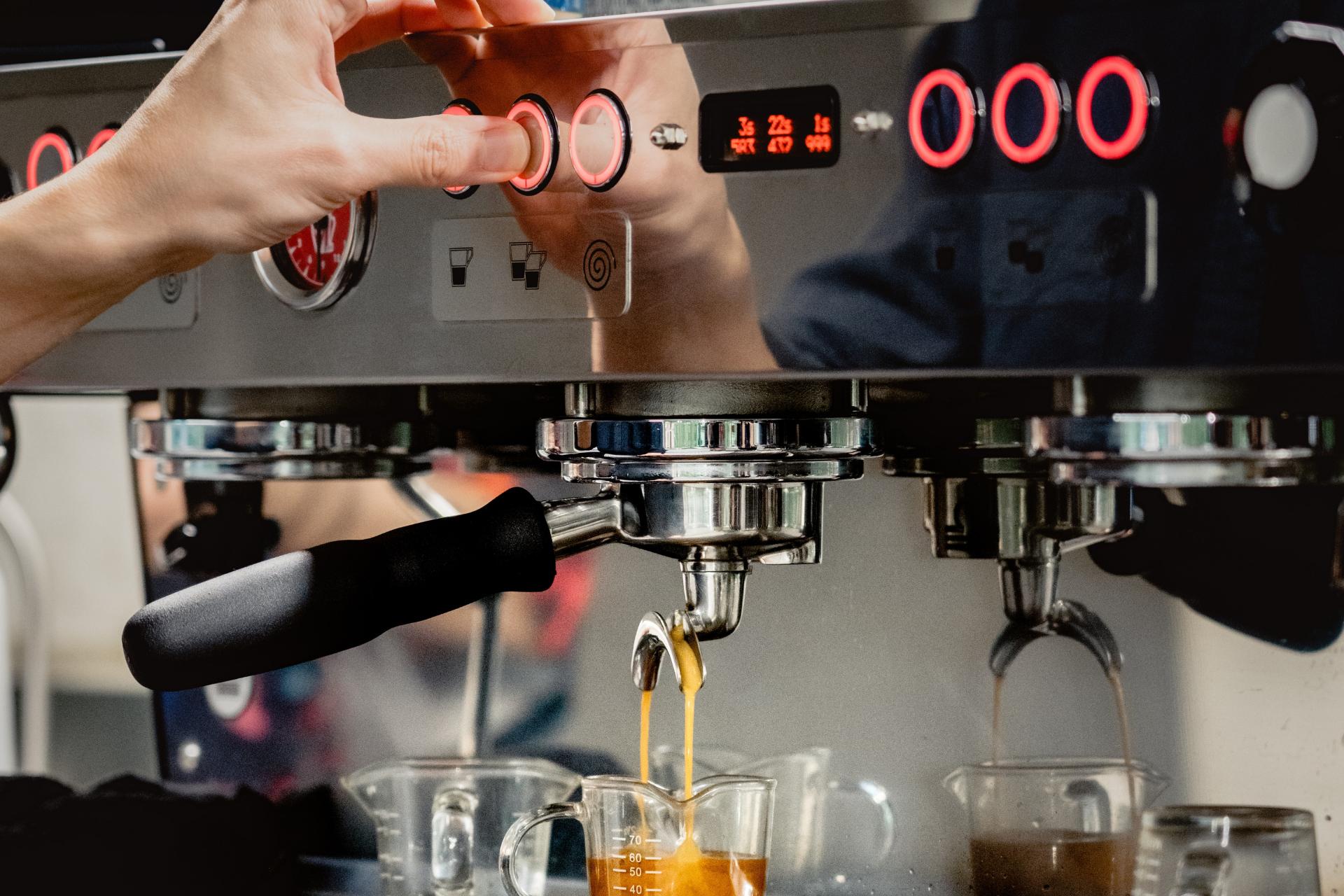 Typ, der eine teure Espressomaschine verwendet, um Kaffee zuzubereiten