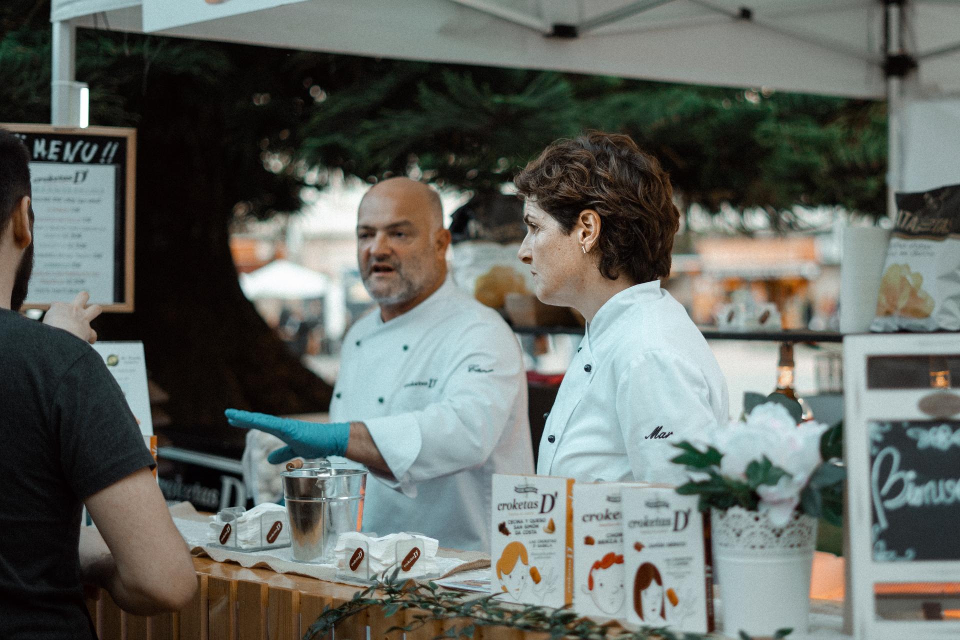 puesto de comida en España con chefs hablando con los clientes