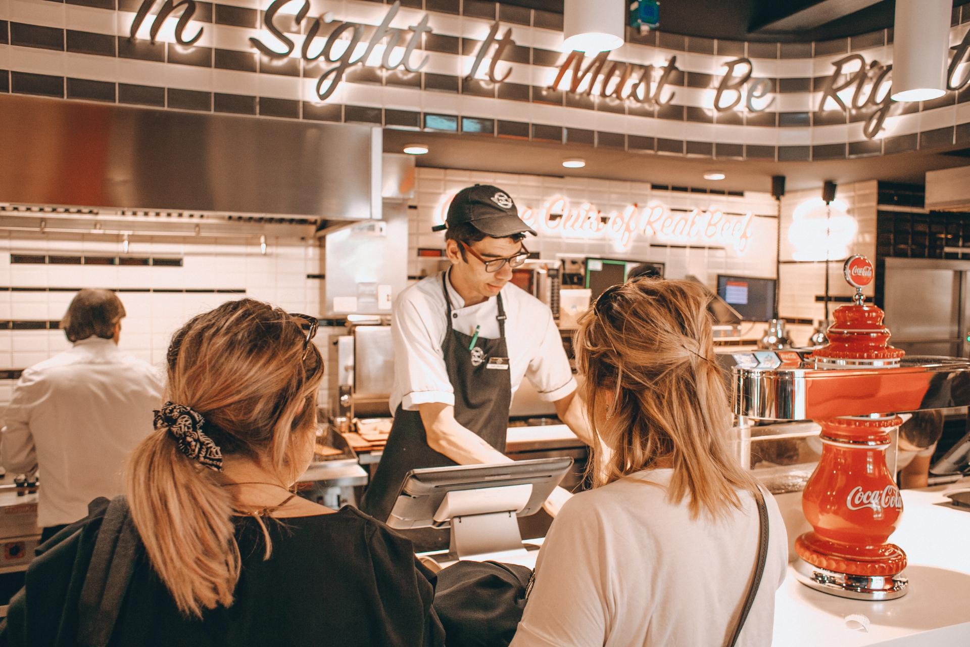 Restaurantmedewerker die in de behoeften van mensen voorziet