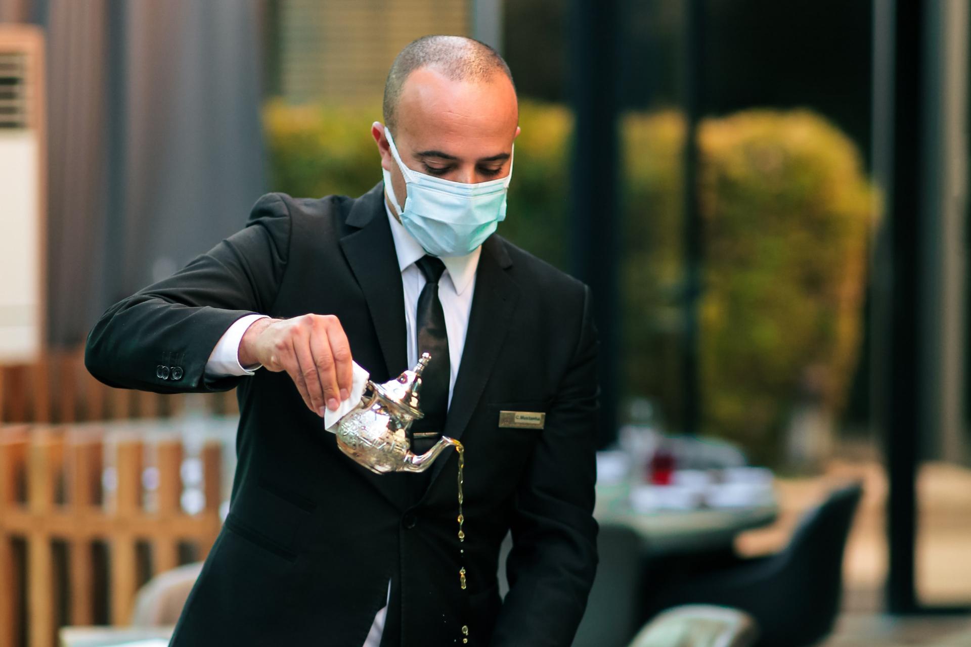 impeccable waiter pouring tea