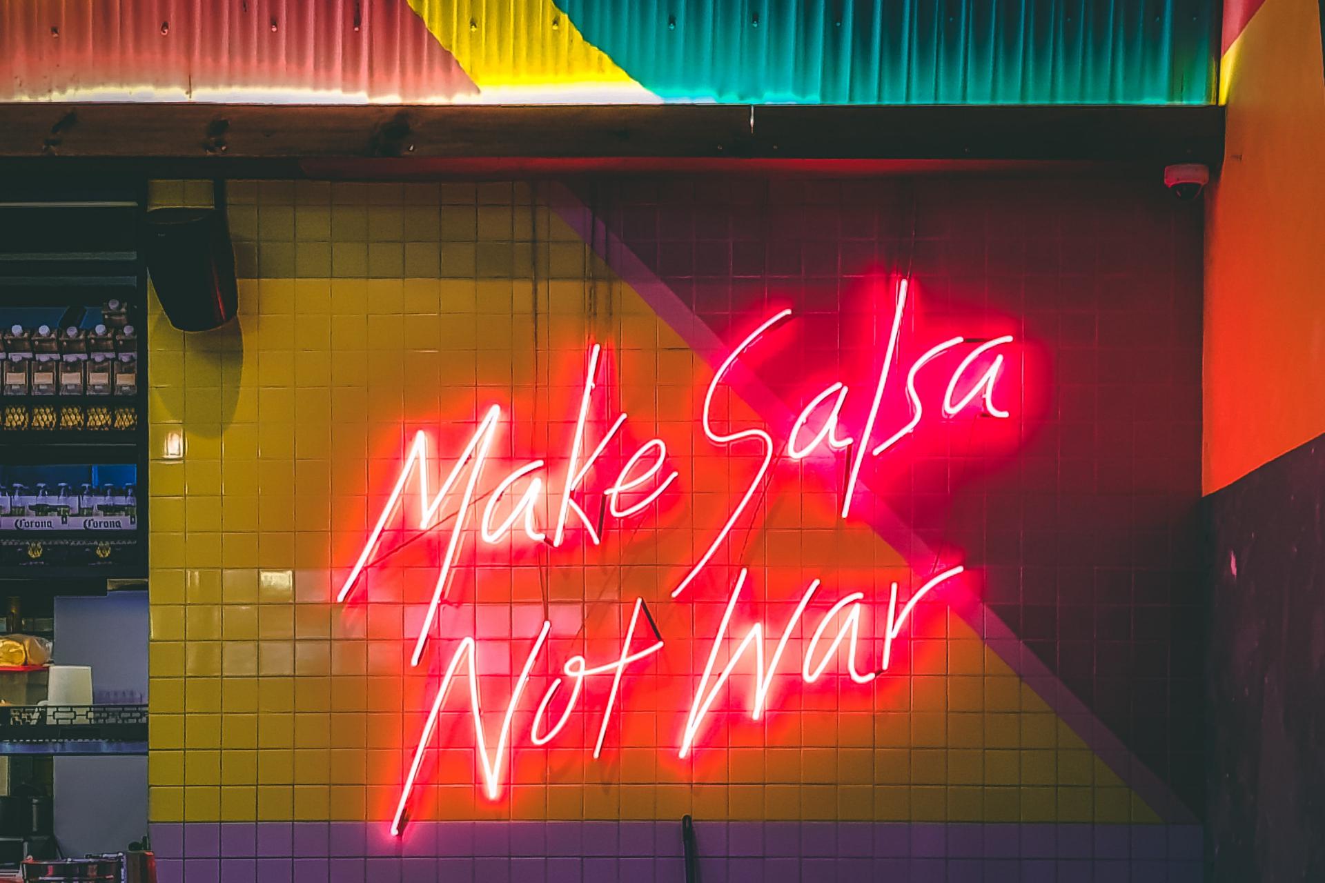 Palabras en una pared que dicen Haz salsa, no la guerra y valores de restaurante