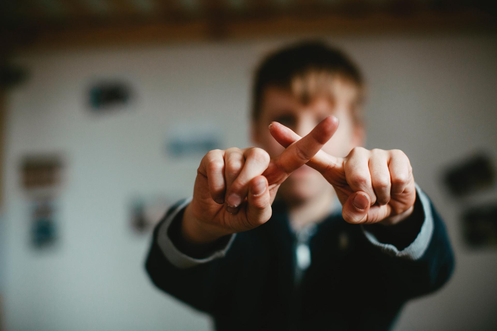 Person, die eine negative X-Handgeste macht, um Missbilligung zu zeigen