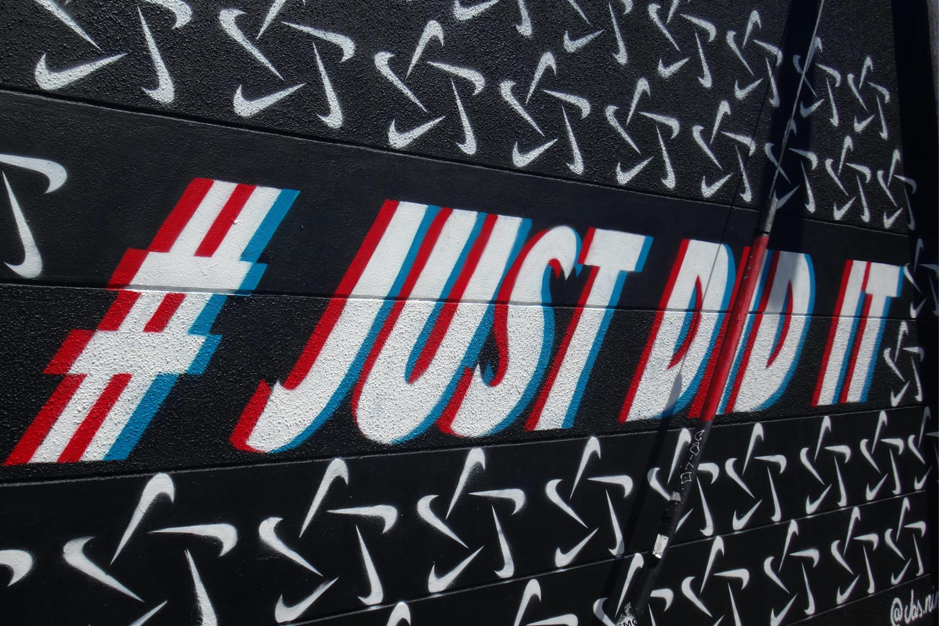 Grafite com uma imitação do slogan da Nike 'apenas faça', mas, em vez disso, 'já fiz'