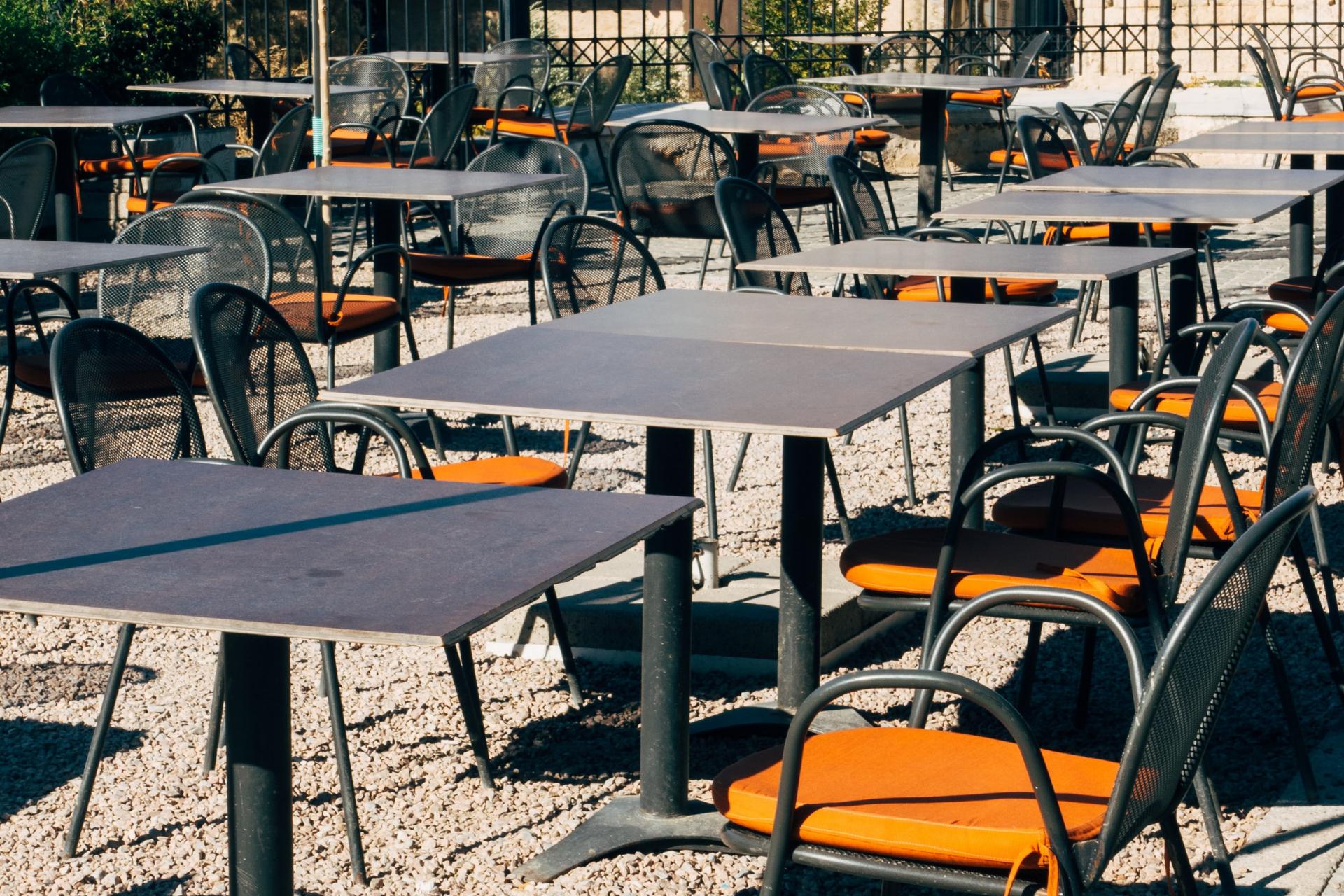 sillas y mesas de exteriores de metal bajo el sol