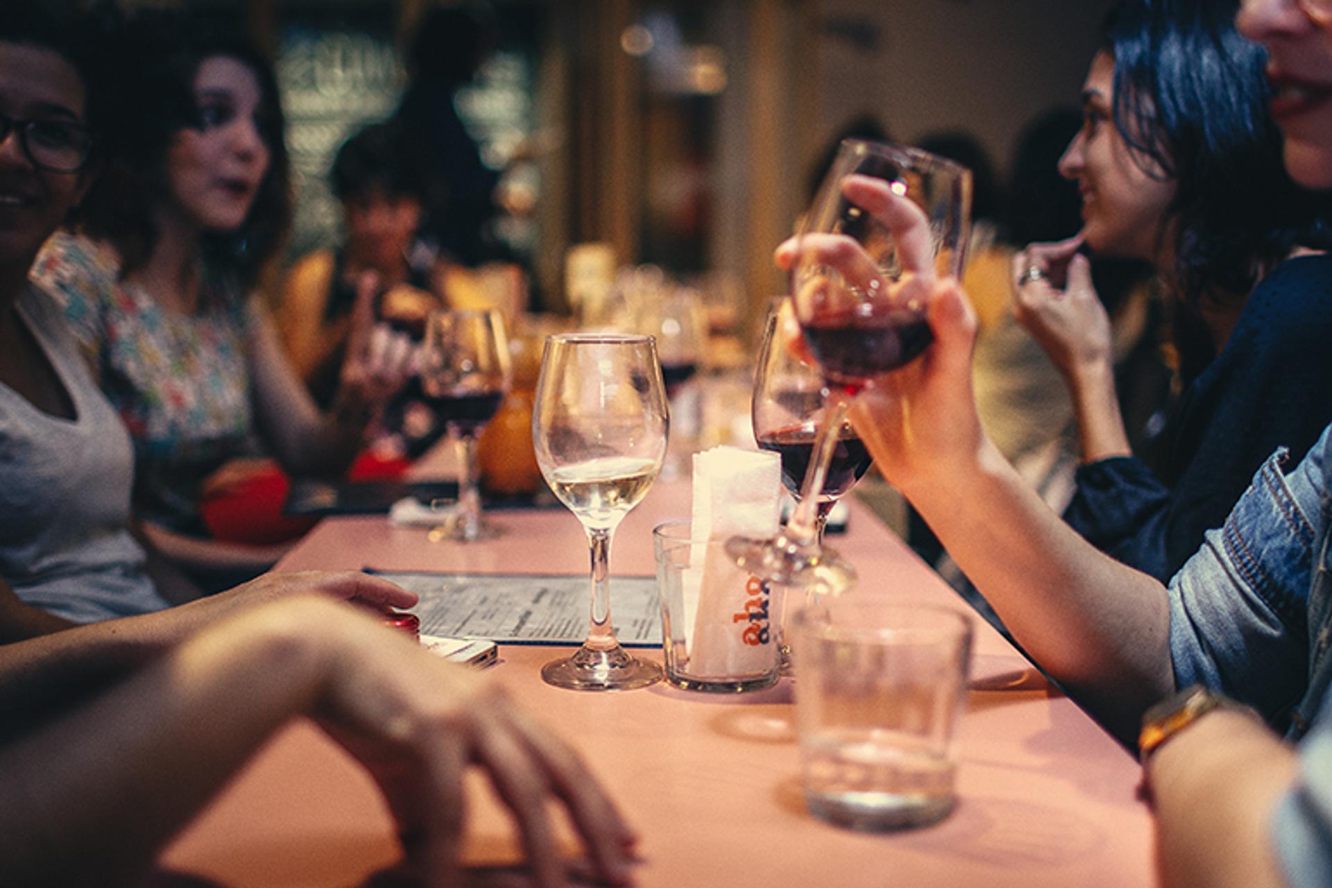 people drinking liquor and talking on dining table