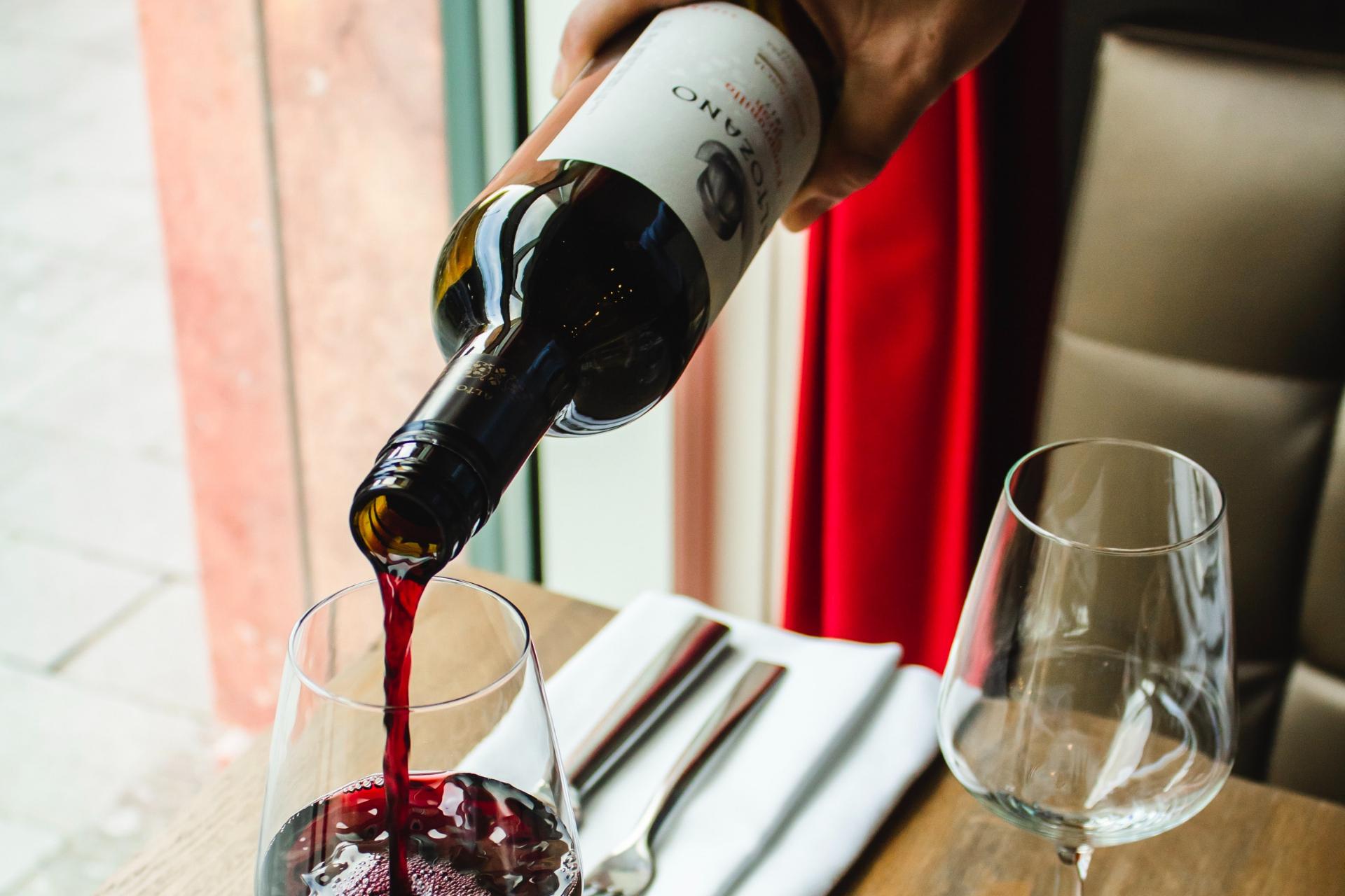 Waiter pouring wine in a glass