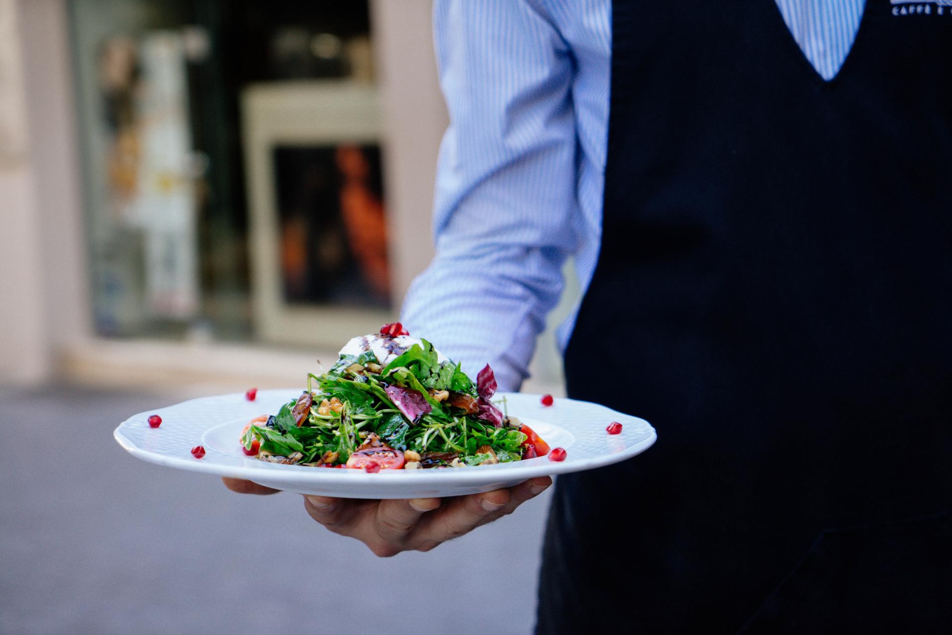 Cameriere che serve cibo con il servizio in stile americano