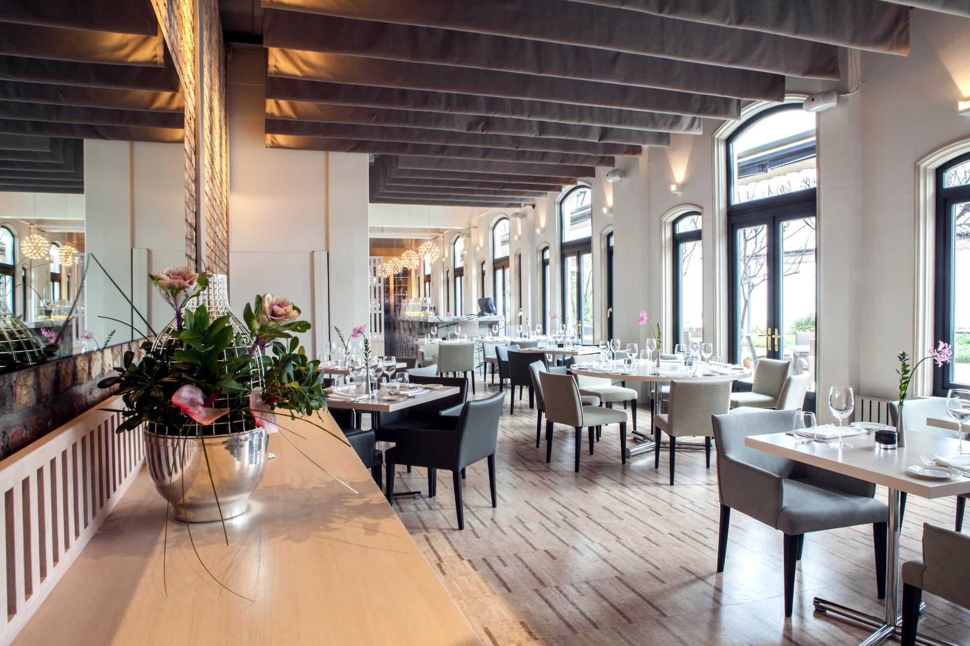 Área de servicio de un restaurante, frente del restaurante elegante con mesas puestas y ventanas panorámicas