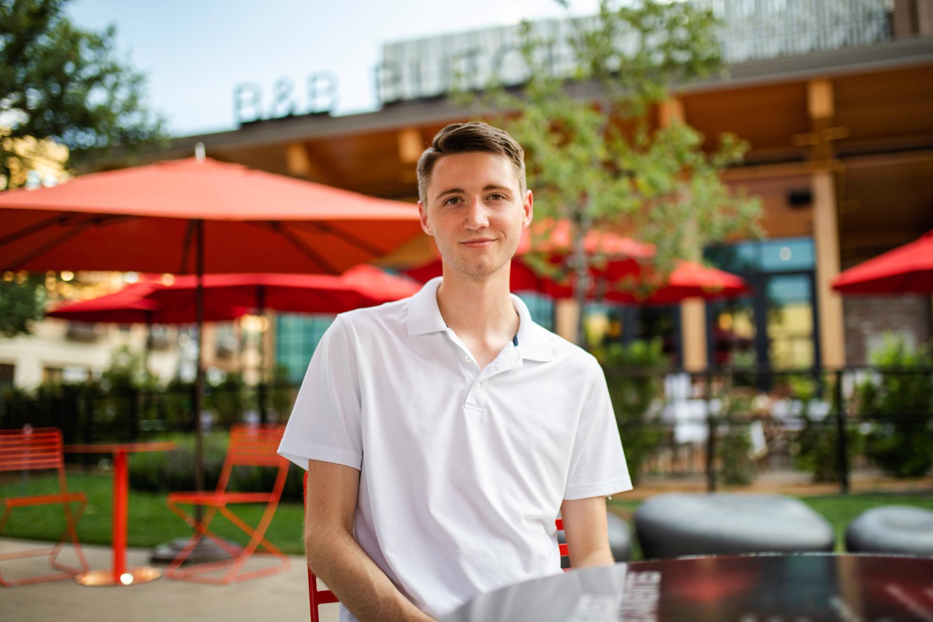 Un mec souriant assis au restaurant