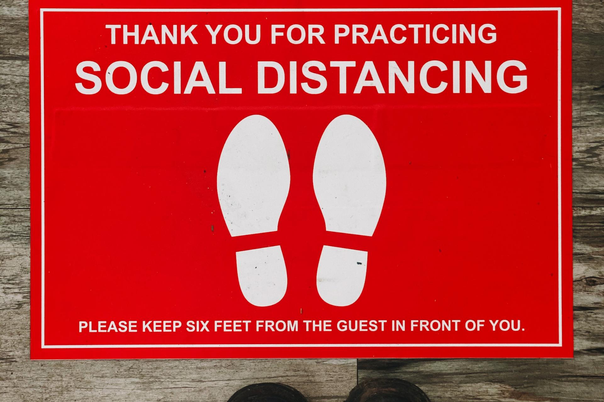 social distancing sign on the floor to keep 6 feet distancing between clients