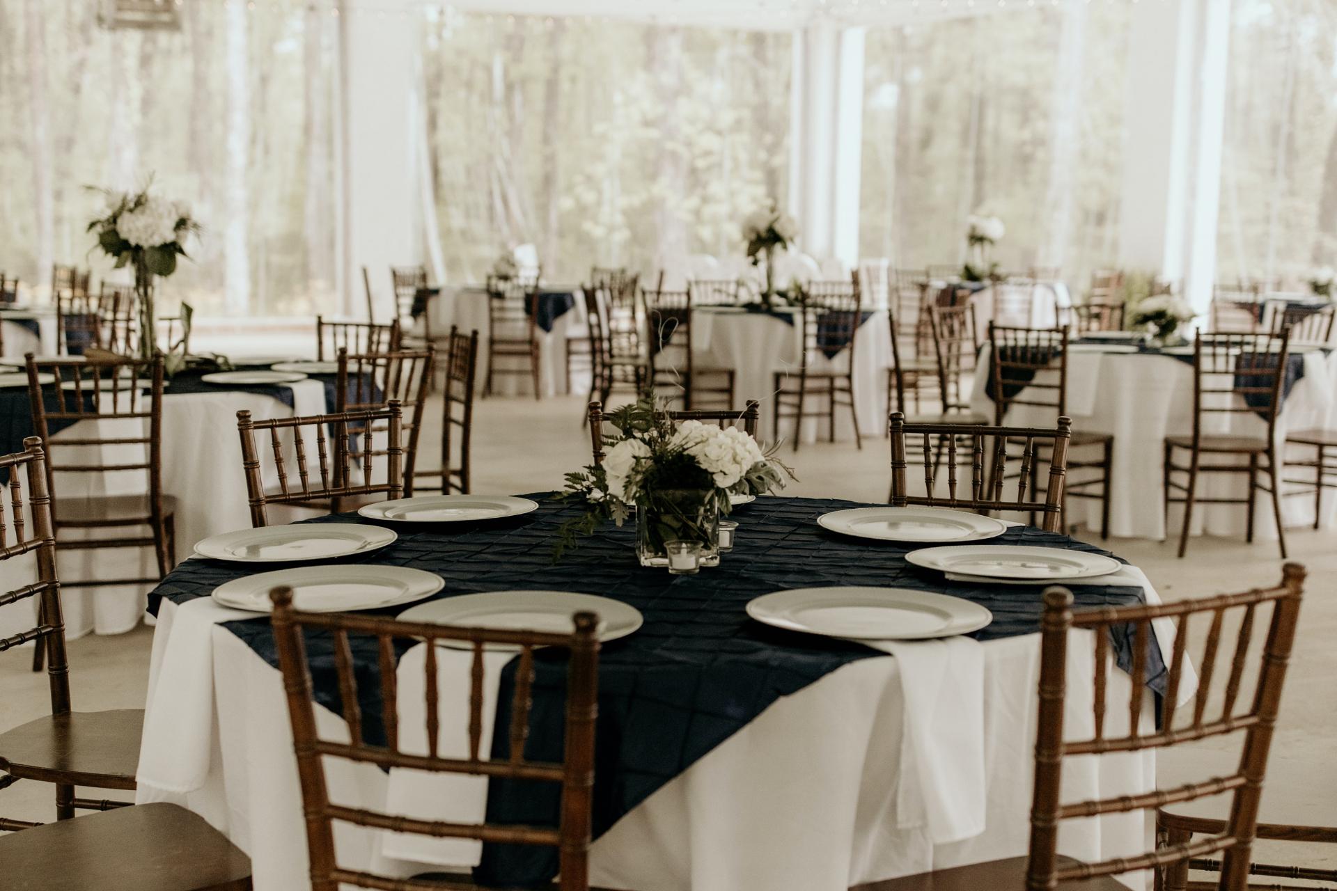 Espacio de restaurante decorado de blanco con mesas con flores en el centro