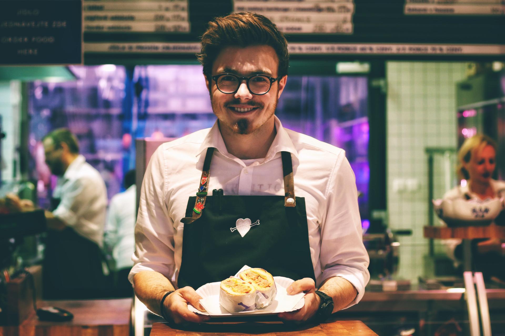 Serveur souriant et qui s'apprête à servir de la nourriture aux clients