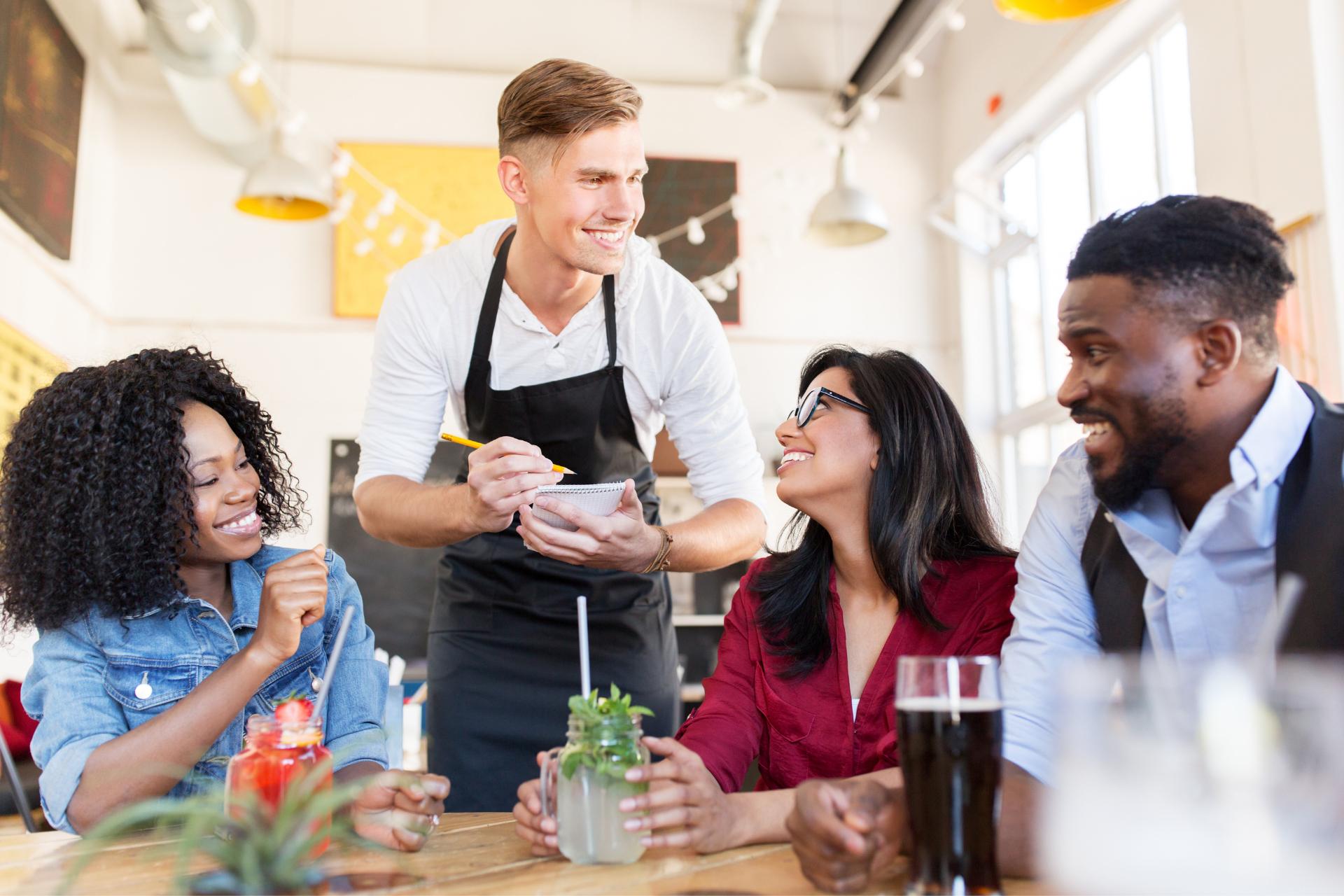 Waiter talking to group of customers