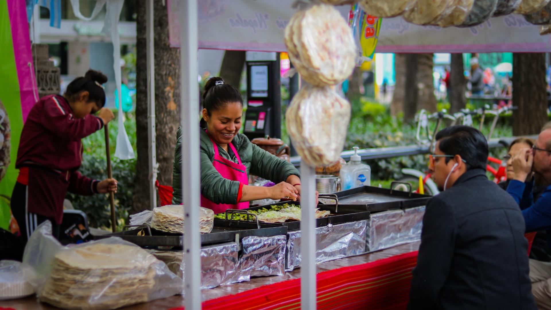 Mujer preparando tacos en la calle