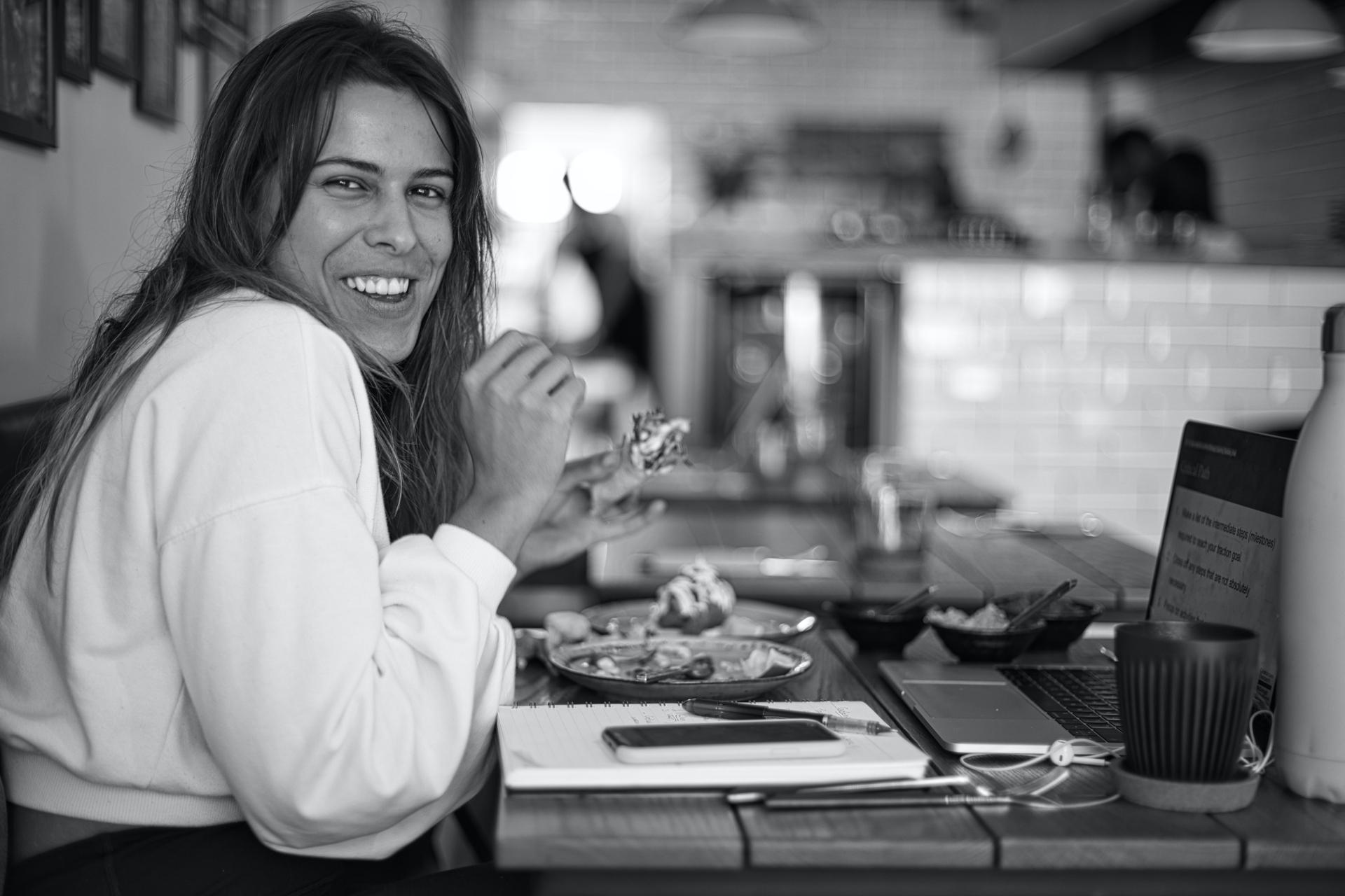 Mujer sonriendo con satisfacción dentro de un restaurante