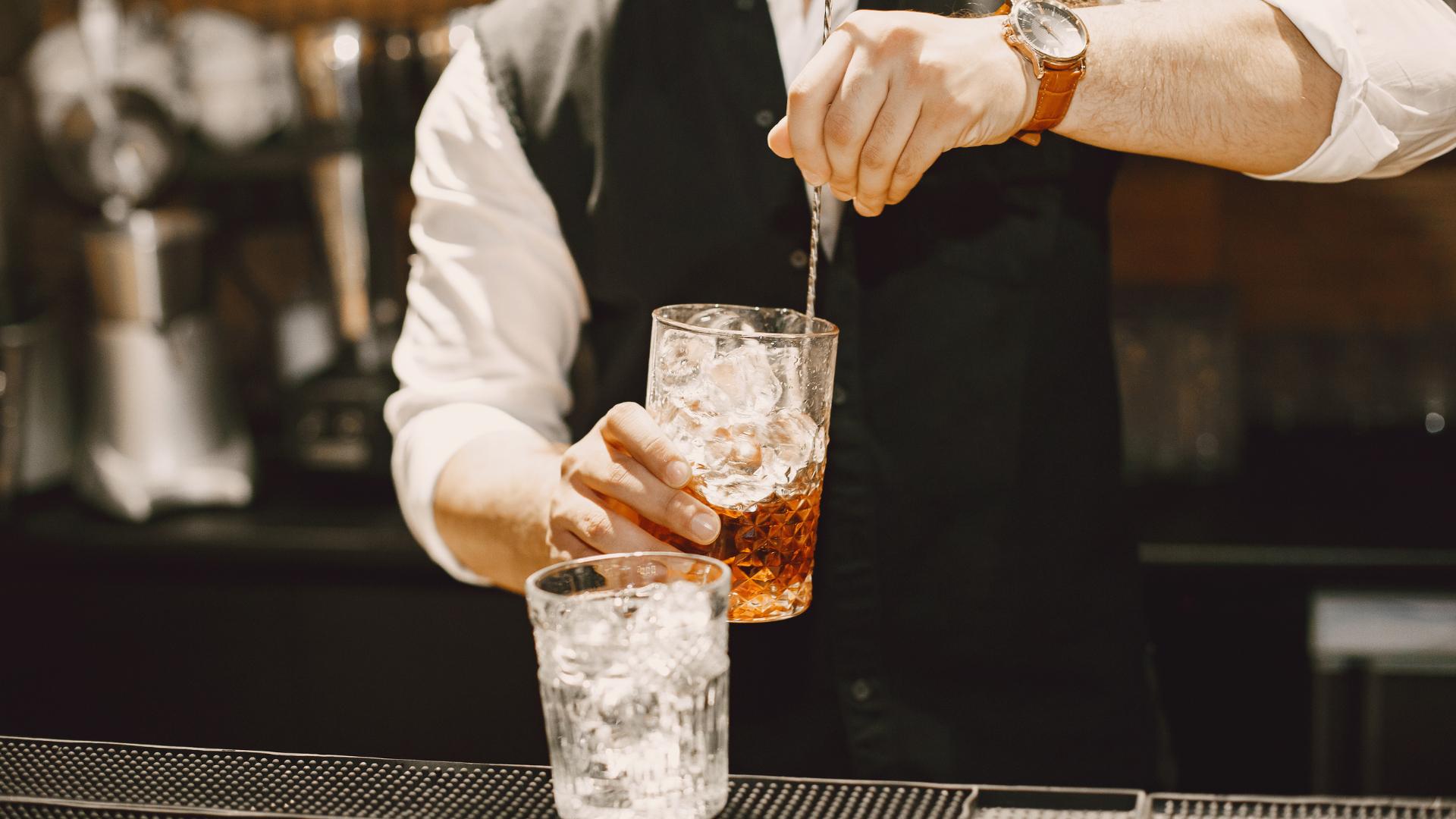 barman mélangeant une boisson avec de la glace