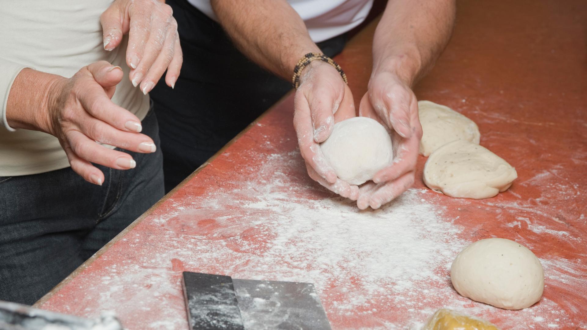 experienced chef teaching and helping another cook