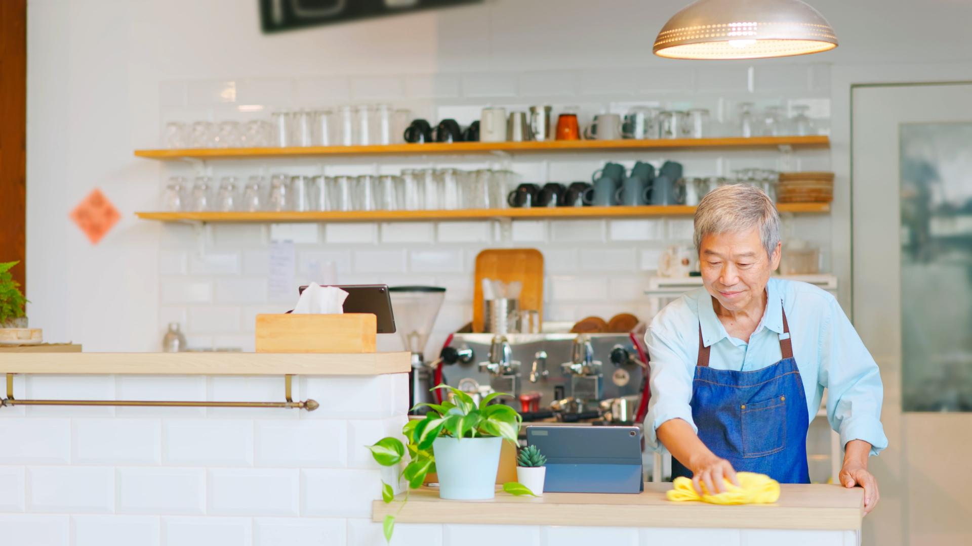 coffee shop worker cleaning the counter with a rag