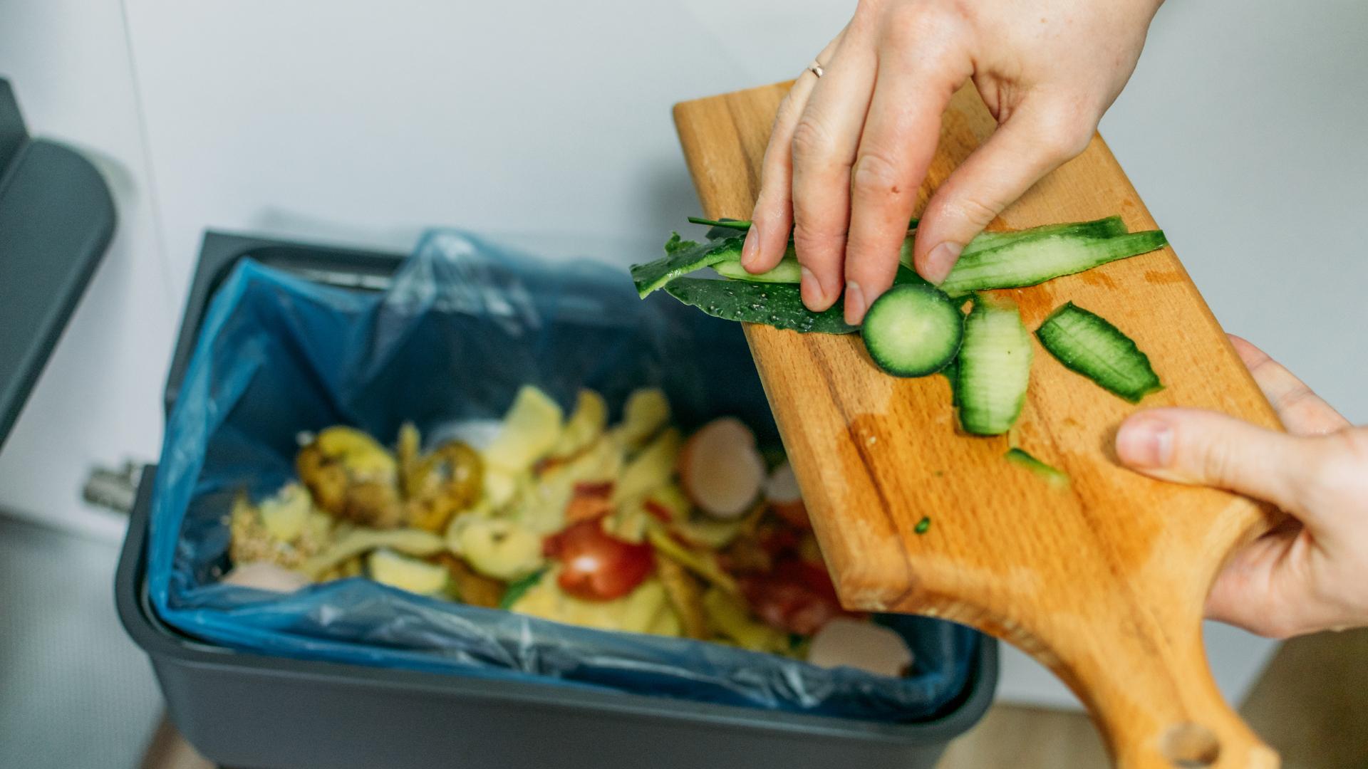 alguém jogando fora restos de comida compostáveis