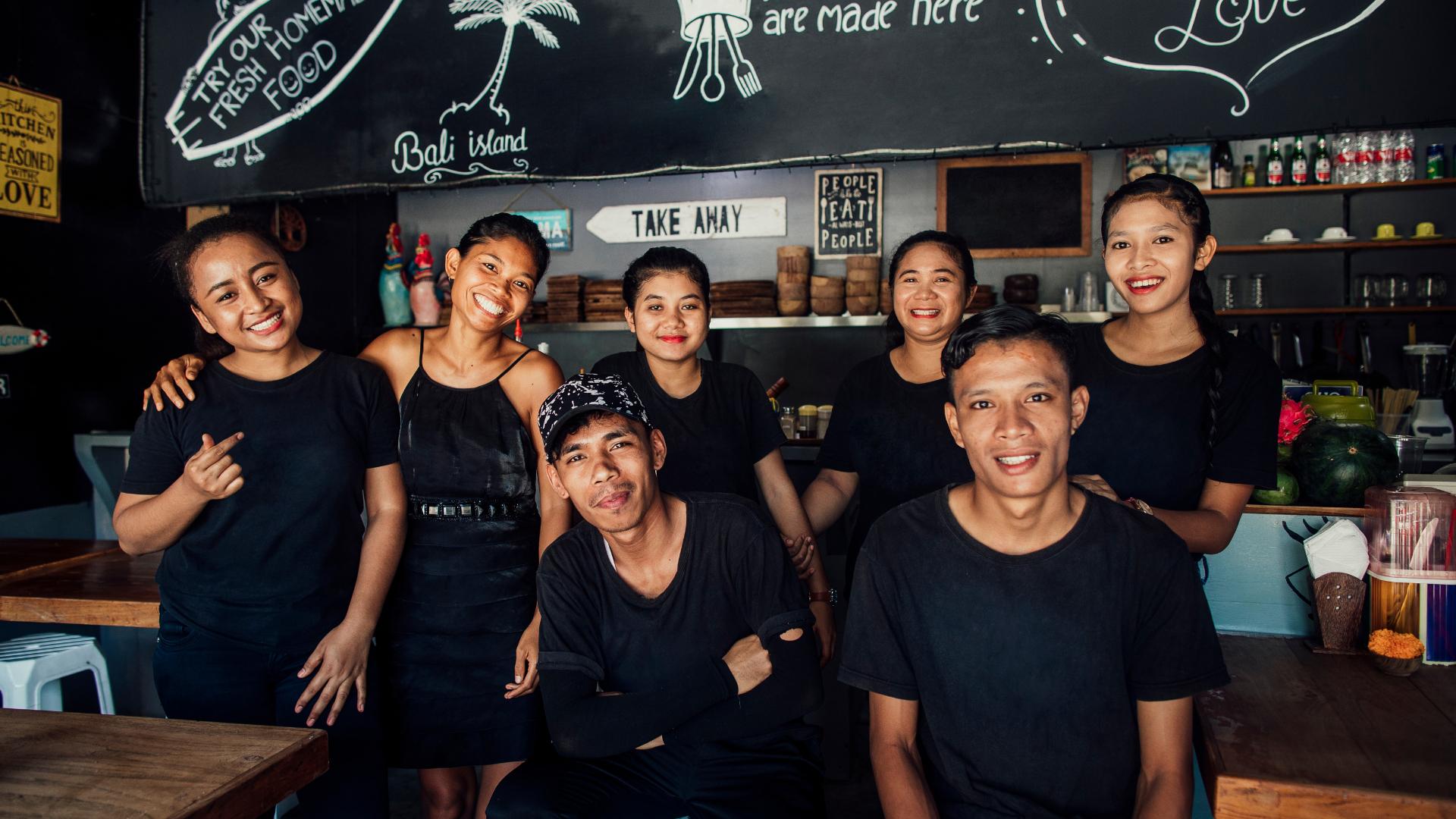 tim staf depan rumah tersenyum di restoran