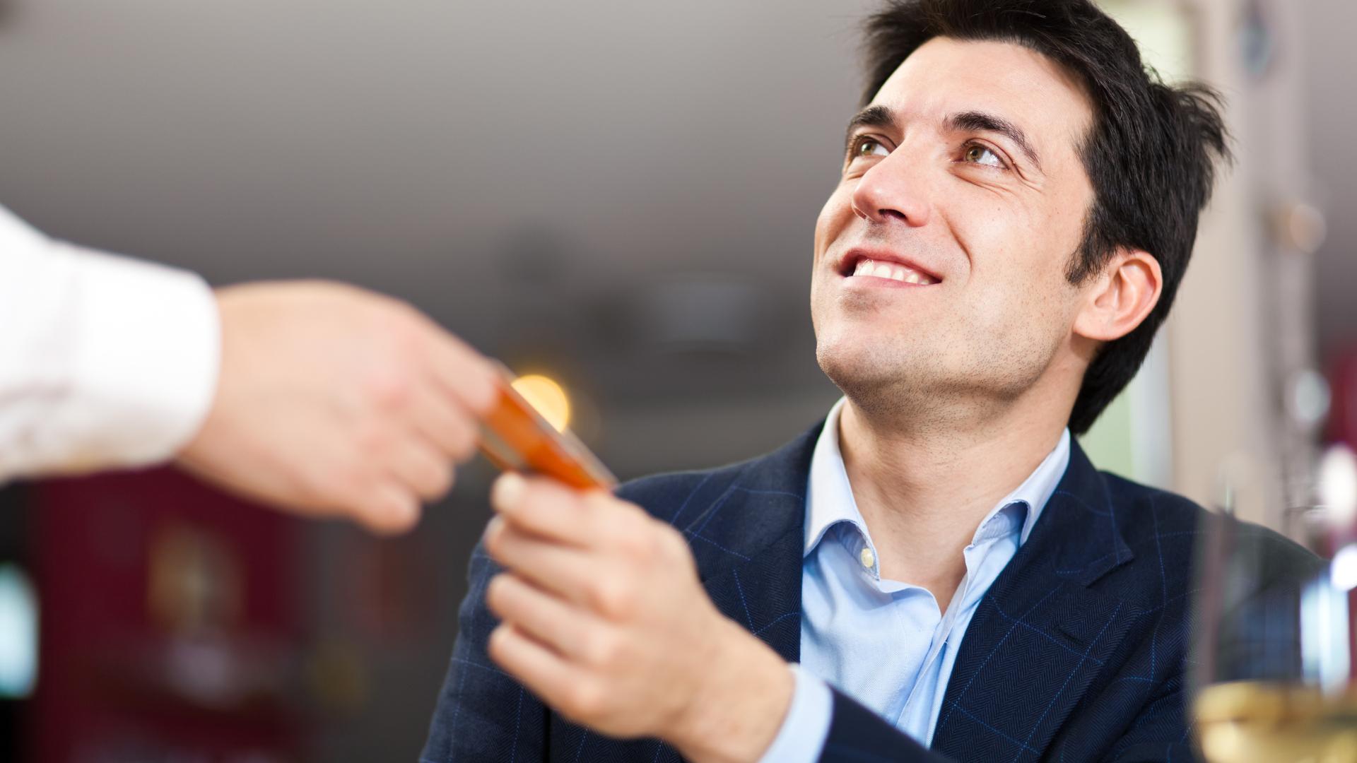 Glücklicher Kunde, der in einem Restaurant bezahlt, um die Kundentreue zu symbolisieren