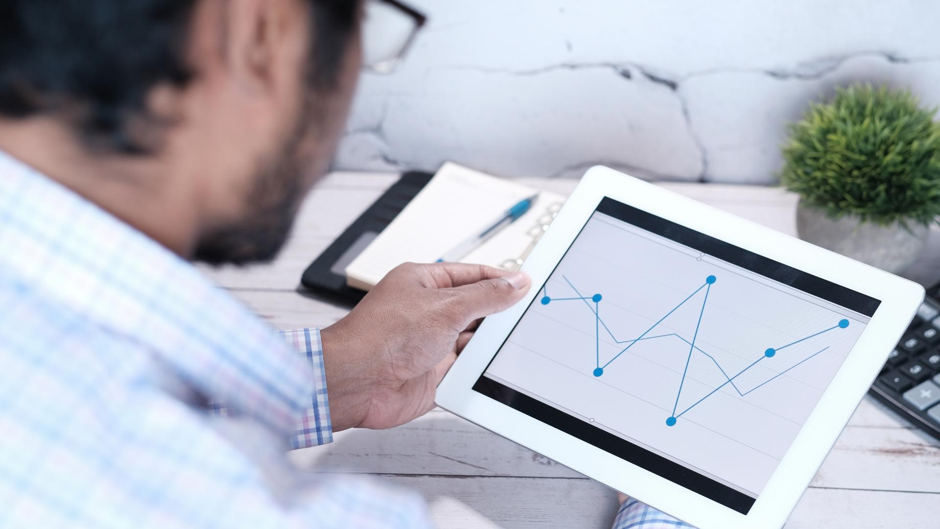 Man reading industry trend metrics on a tablet