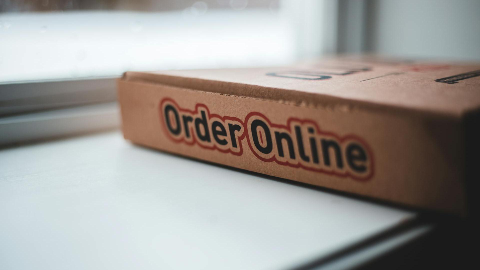 Pizzakarton mit der Aufschrift „Online-Bestellung“ an der Seite, um darauf hinzuweisen, dass der Service verfügbar ist