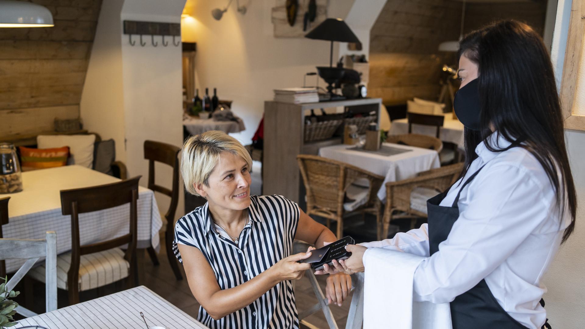 cliente che paga in un ristorante utilizzando un sistema pos