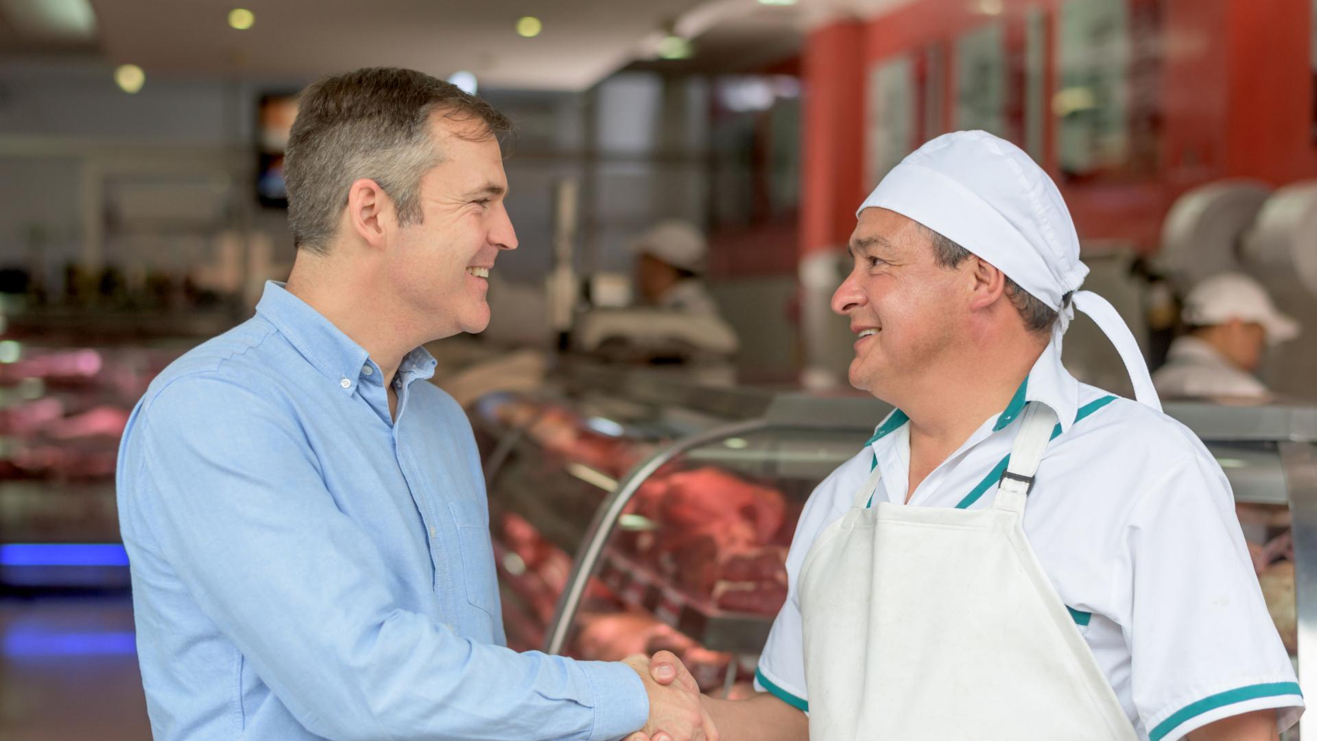 Restaurantbesitzer schüttelt einem Lieferanten die Hand