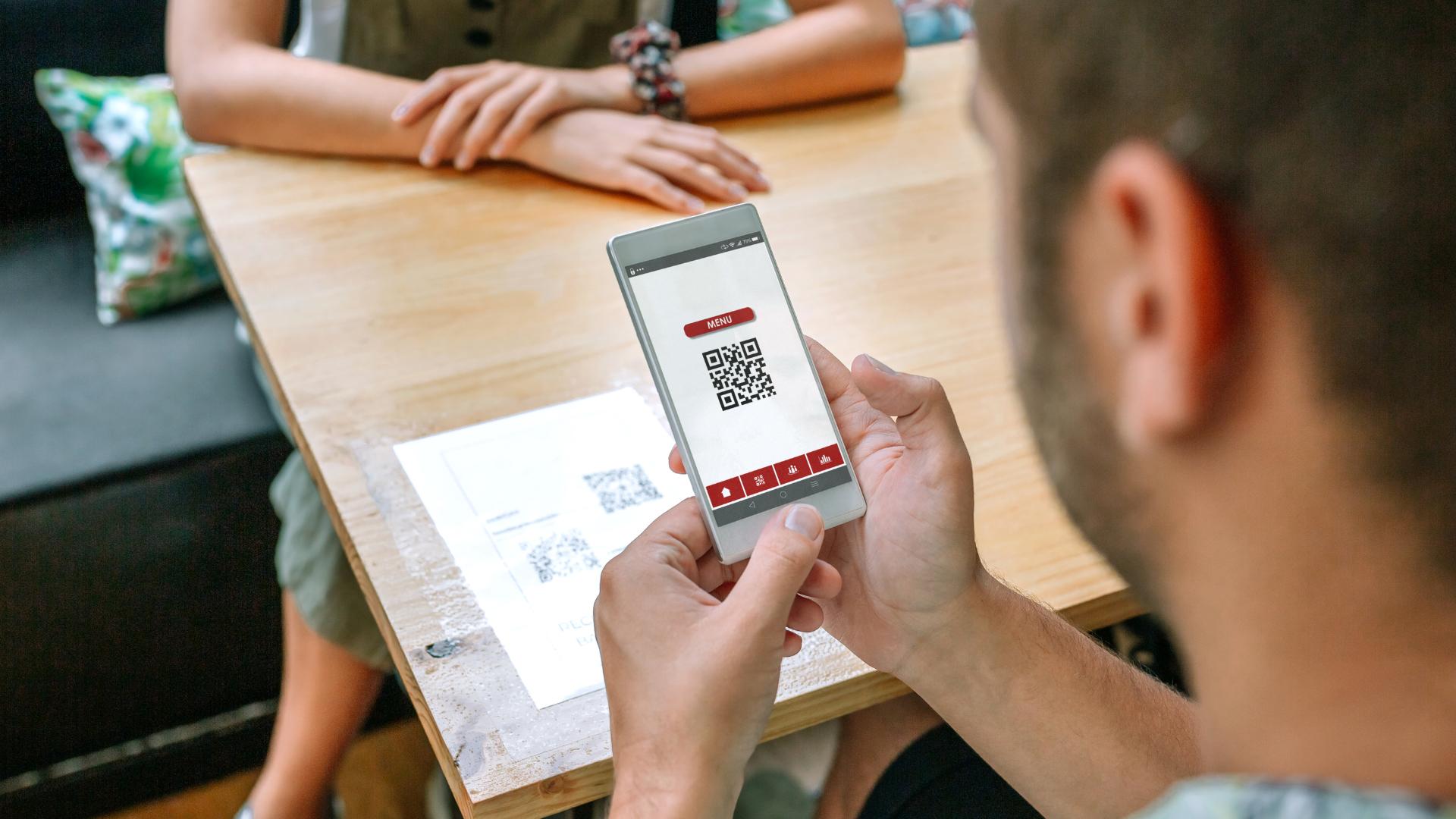 Customer reading restaurant's qr code menu on a table