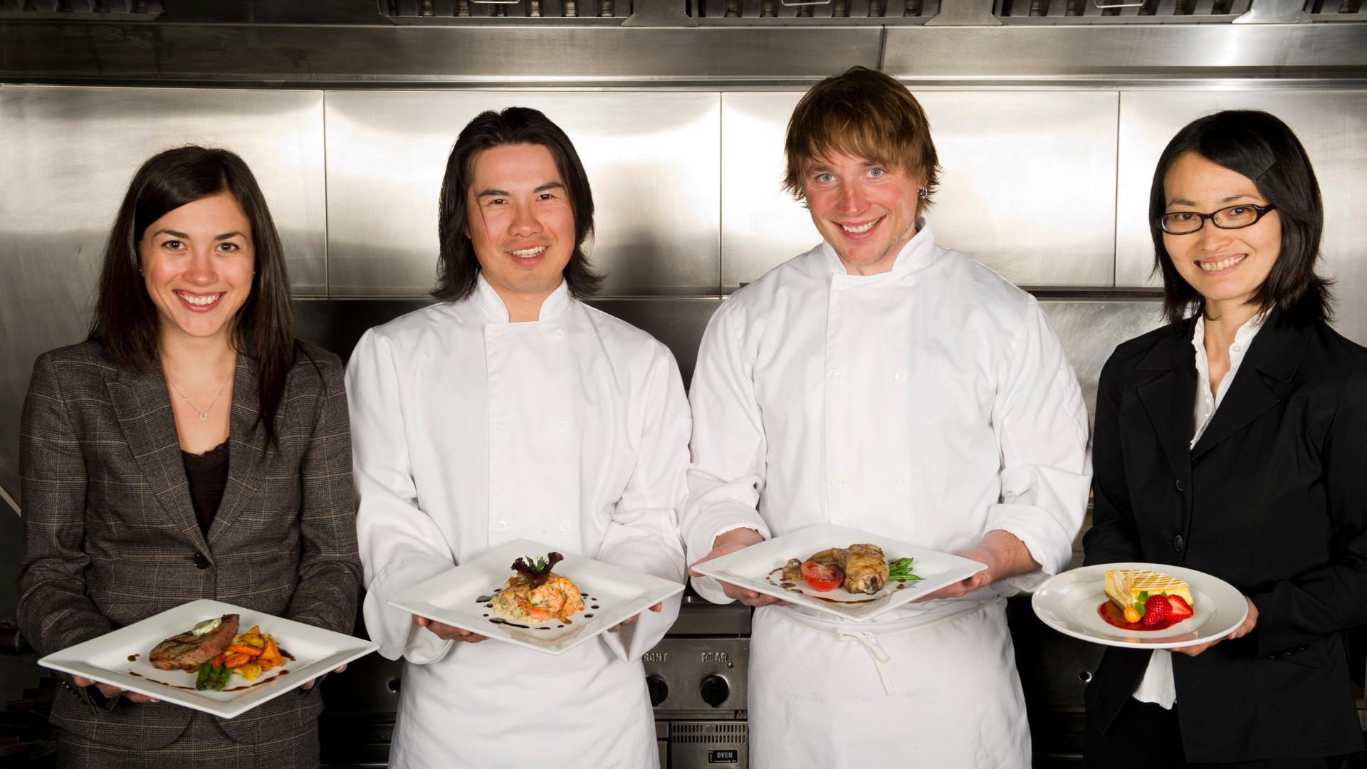 restaurant staff members holding restaurant dishes