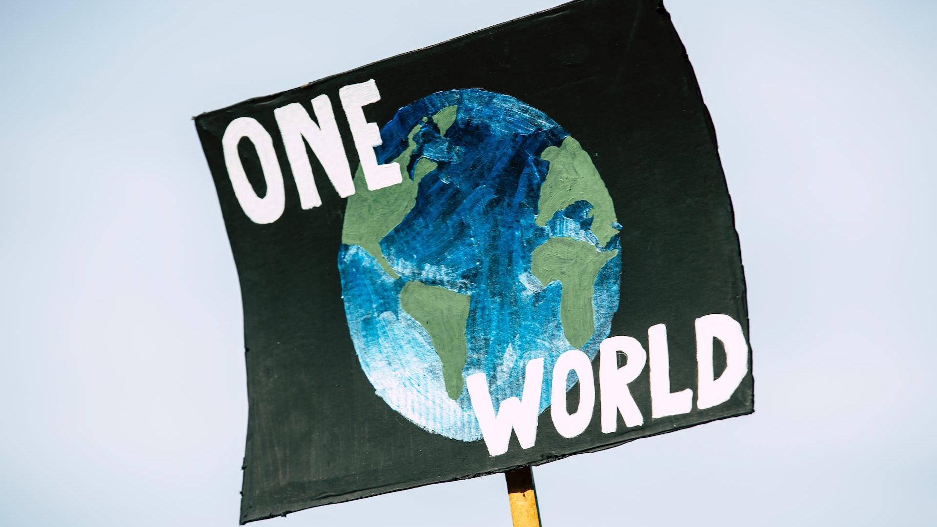a sign with a world and the words one world to represent sustainability