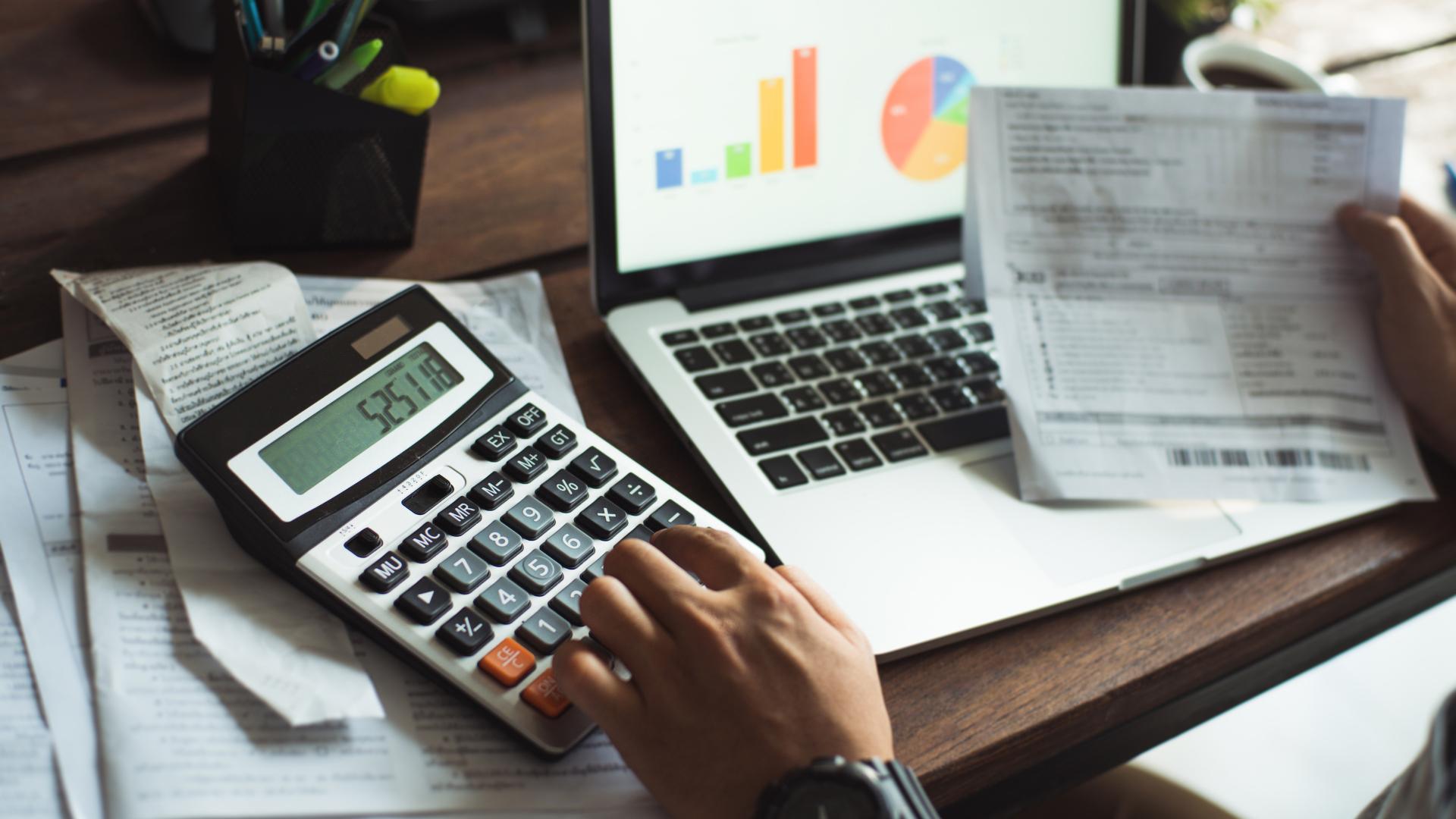 manager tracking costs looking at documents and a calculator