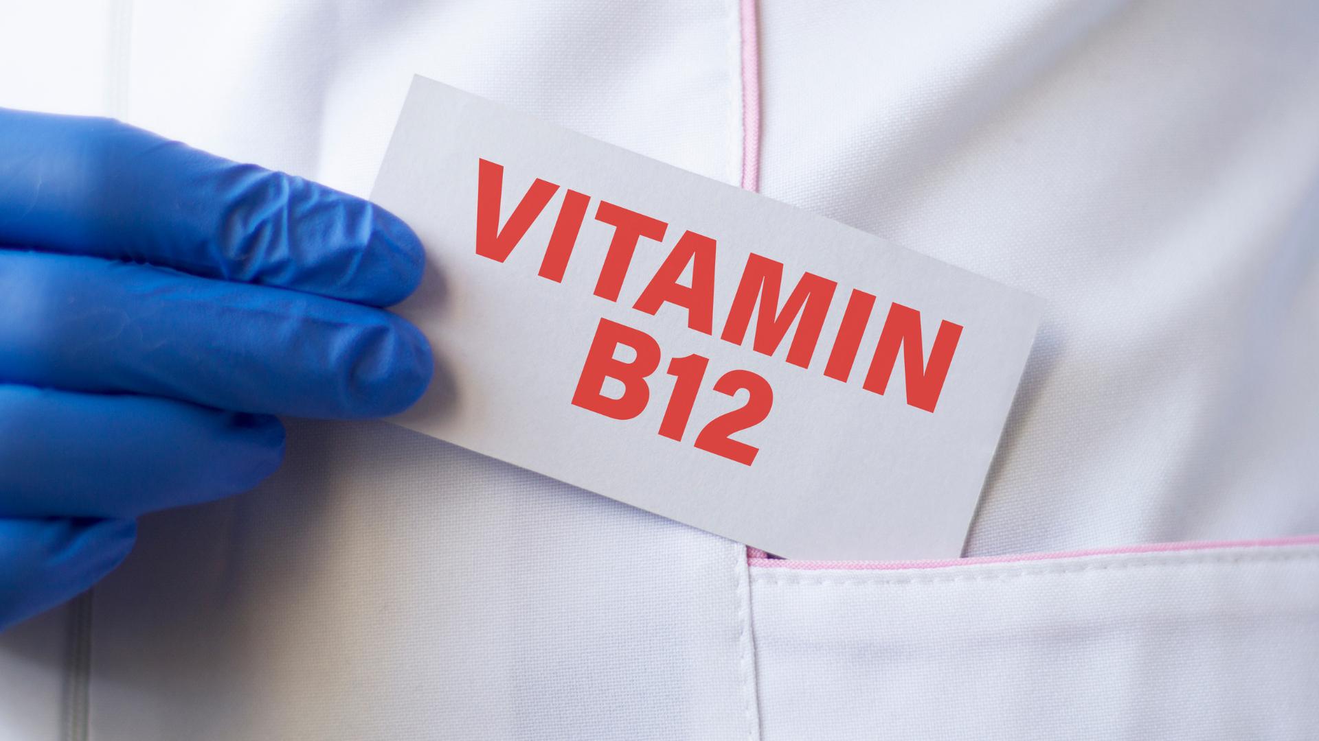 Arzt hält ein Schild mit der Aufschrift „Vitamin B12“.